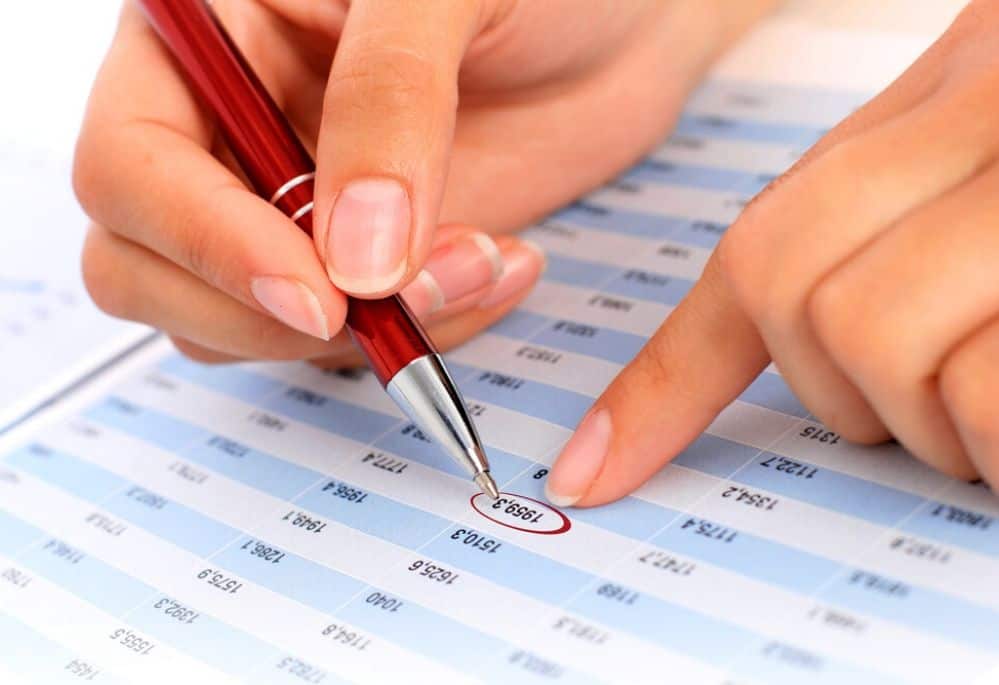 Woman checking numbers on spreadsheet as a virtual bookkeeper