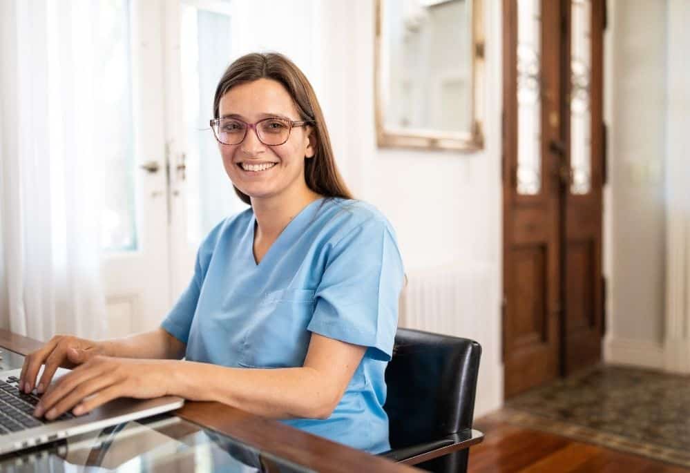 woman sitting at desk working from home as a nurse