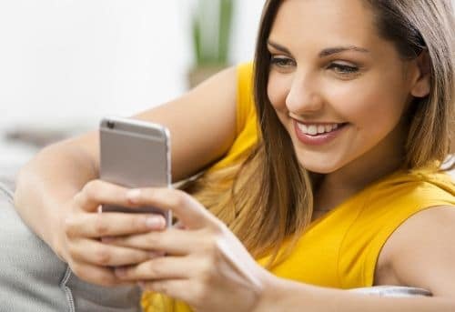 Image of woman texting on her phone doing side hustle to get paid to text